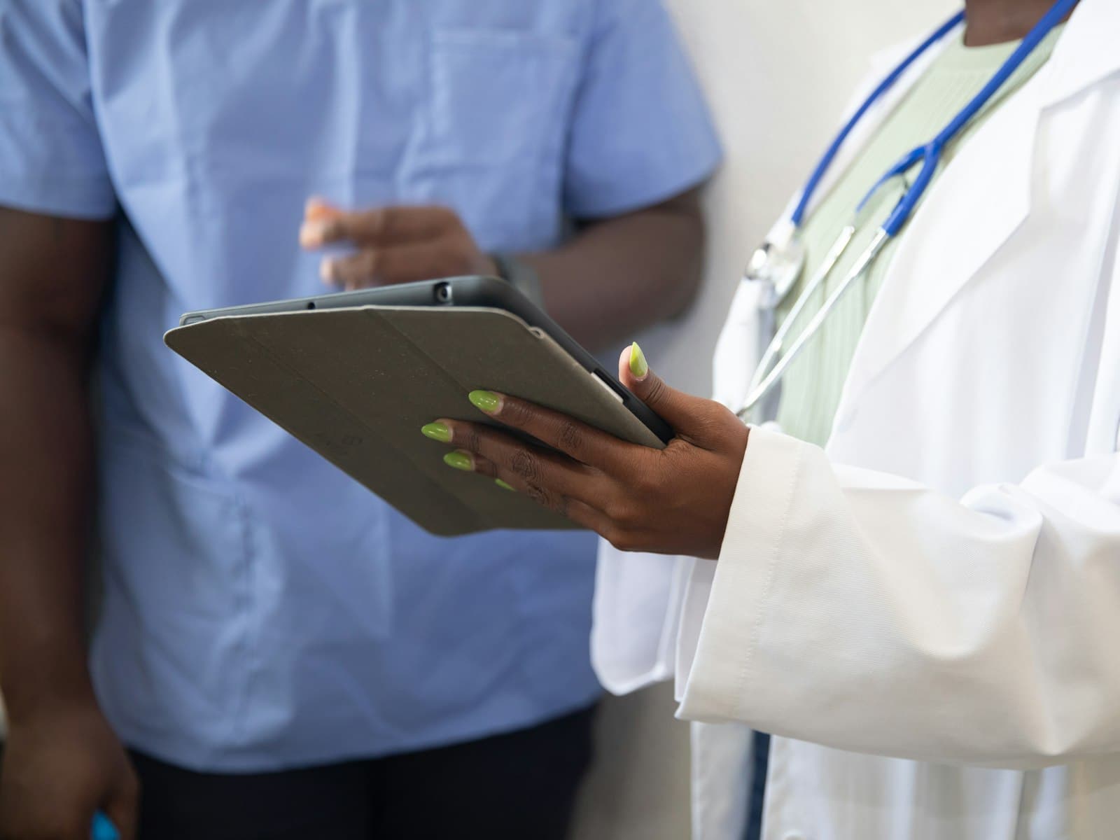 Physician reviewing notes on a tablet with a colleague